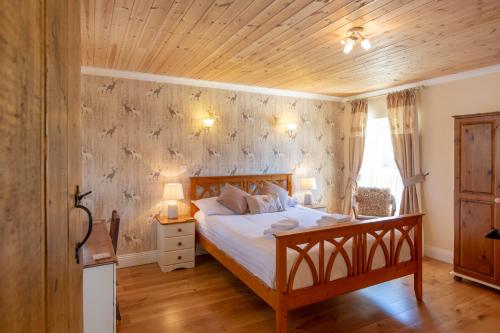 a bedroom with a bed and a wooden ceiling at The Coal House in Kidwelly