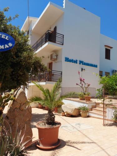 a building with a potted plant in front of it at Hotel Plammas in Santa Maria Navarrese