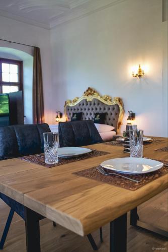 a wooden table with plates and glasses on top of it at Innviertler Versailles in Aurolzmünster