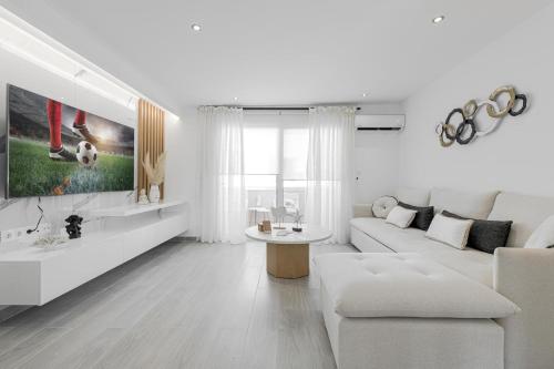 a white living room with a couch and a table at Diogenis Seaside Suite in Rethymno Town