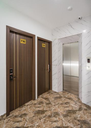 two brown doors in a room with a marble floor at Wind Hotel in Hanoi