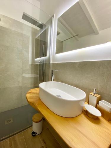 a bathroom with a large white sink on a wooden counter at B&B Anastasia in Santa Teresa Gallura