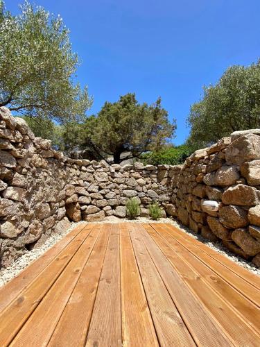 a stone wall with a wooden floor in front of it at B&B Anastasia in Santa Teresa Gallura