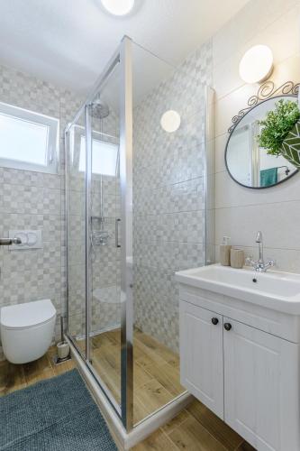 a white bathroom with a shower and a sink at Holiday Home Nono Ante with heated pool in Supetar