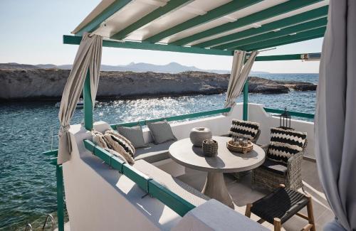 stół i krzesła na łodzi w wodzie w obiekcie Terra Mare Suites w mieście Agia Irini Milos
