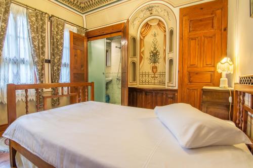 a bedroom with a bed and a wooden door at Old Legends Hotel in Plovdiv
