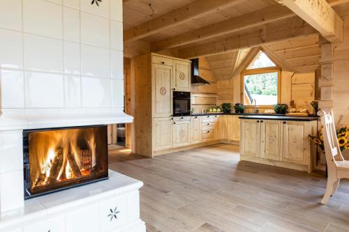 a kitchen with a fireplace in a log cabin at udanypobyt Tatrzańskie Domy in Kościelisko