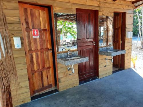 Baño con 2 lavabos en una cabaña de madera en Resort Ondas Praia en Porto Seguro