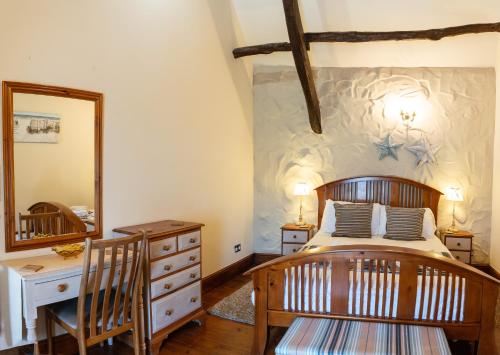 a bedroom with a bed and a dresser and a mirror at Bryntowy in Kidwelly