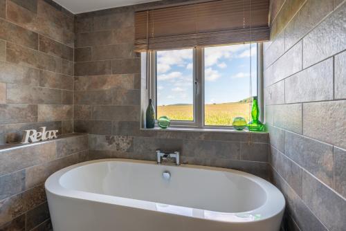 a bath tub in a bathroom with a window at Bryntowy in Kidwelly