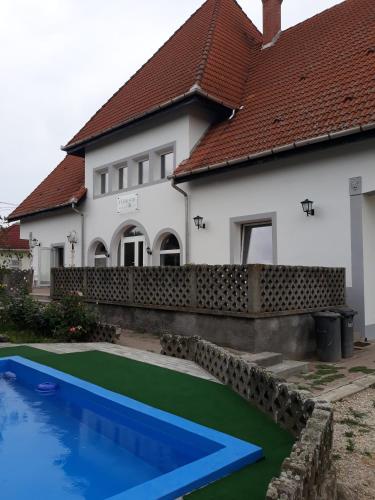 a house with a swimming pool in front of a house at St. Kristóf Vendégház in Abádszalók