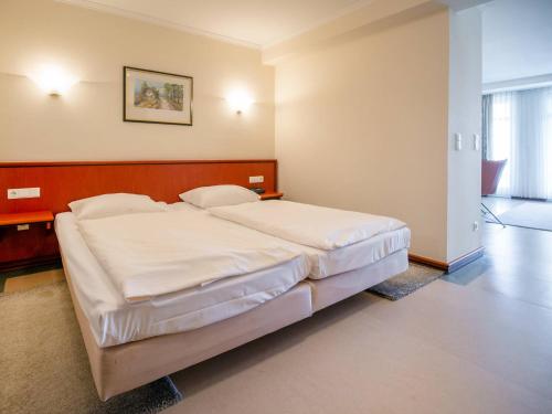 ein Schlafzimmer mit einem großen Bett mit weißer Bettwäsche in der Unterkunft Strandvillen Binz - 1-Raum-Ferienwohnung mit Meerblick und Balkon SV-763 in Binz