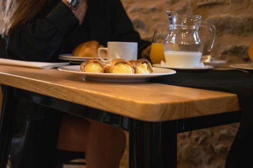 ein Tisch mit Tellern mit Croissants und einer Tasse Milch in der Unterkunft Casa Rural Camino Real in Melide