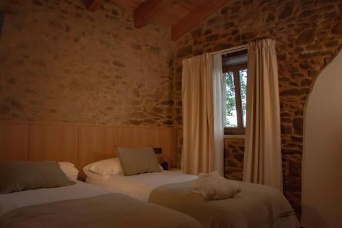 two beds in a room with a window at Casa Rural Camino Real in Melide