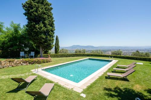 Una piscina en un patio con tumbonas. en Villa Colomba by Mmega, en Lastra a Signa