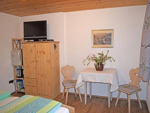 Habitación con mesa, TV y dormitorio. en Haus Wimbachtal, en Ramsau