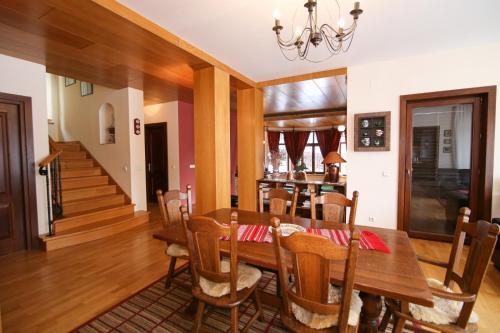 Transylvanian Villa في بريدال: غرفة طعام مع طاولة وكراسي خشبية