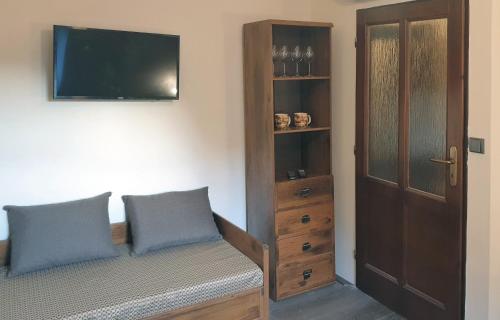 a bedroom with a bed with two pillows and a tv at Bunkr Karlštejn in Karlštejn