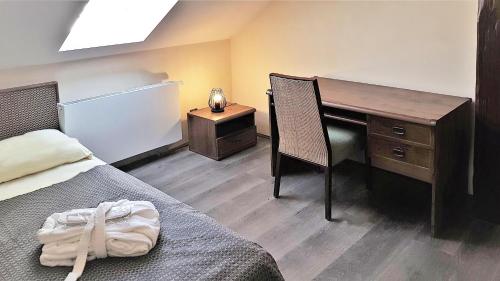 a bedroom with a desk and a bed with a chair at Bunkr Karlštejn in Karlštejn