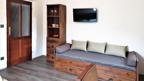 a room with a couch with a tv on a wall at Bunkr Karlštejn in Karlštejn