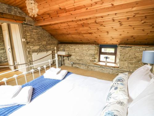 a large bed in a room with a wooden ceiling at Pant Y Rhedyn in Llandrindod Wells