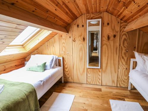 a room with two beds in a wooden cabin at Pant Y Rhedyn in Llandrindod Wells