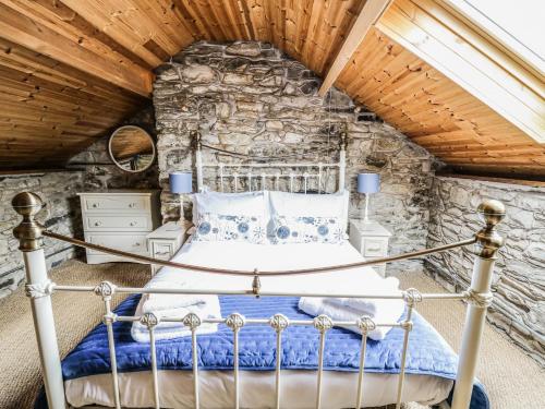 a bedroom with a bed in a stone wall at Pant Y Rhedyn in Llandrindod Wells