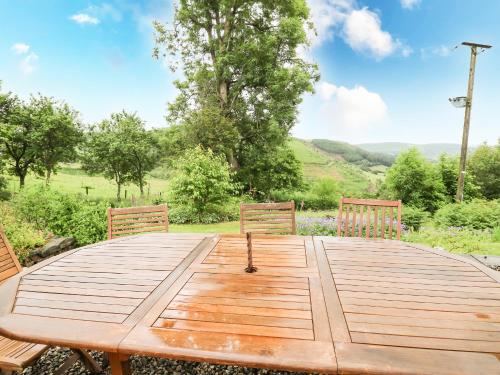 a wooden table with two chairs sitting around it at Pant Y Rhedyn in Llandrindod Wells