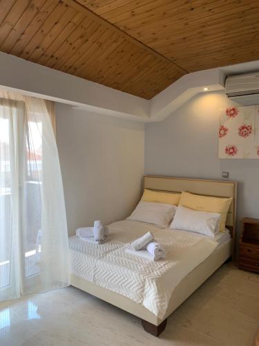 a bedroom with a bed with a wooden ceiling at Hotel Platon in Nei Poroi