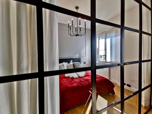 a room with a red bed and a window at F L O R E N T I N Design Apartment ChicLife in Bergamo