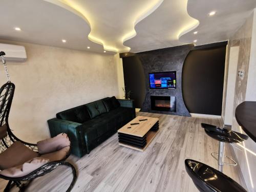 a living room with a green couch and a table at Brend new luxurious apartment in downtown with free parking in Novi Sad