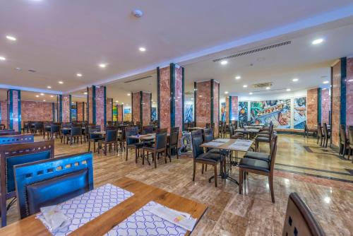 een restaurant met tafels en stoelen in een kamer bij Amara Comfort Resort in Kemer
