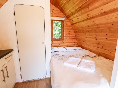 a small bedroom with a bed in a wooden cabin at Lovesome Pod in Northallerton