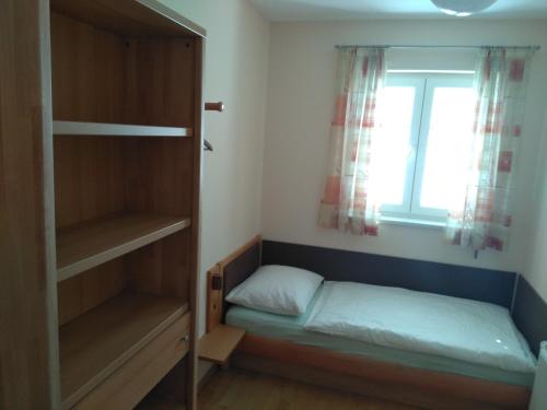 een kleine slaapkamer met een bed en een raam bij Appartement Enzi in Sekirn