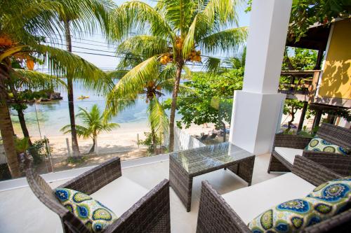 einen Balkon mit Stühlen und einem Tisch sowie Strandblick in der Unterkunft Bella Luna Beach Condo #227473 in West End