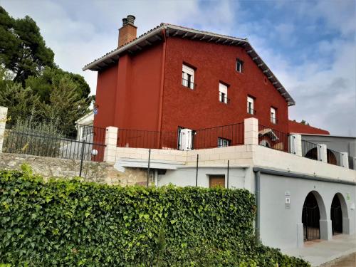 a red brick building with a fence in front of it at Casa rural "Garnacha de Borja" guest home in Borja