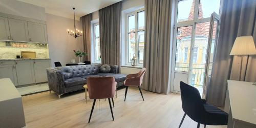 a living room with a couch and a table and chairs at DK Premium Romantyczna Secesja in Olsztyn