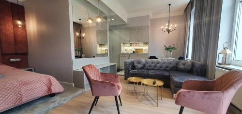 a living room with a couch and a table and chairs at DK Premium Romantyczna Secesja in Olsztyn