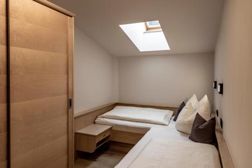 a small room with a bed and a skylight at FRAU GANS - pure mountain apartments in Saalbach Hinterglemm