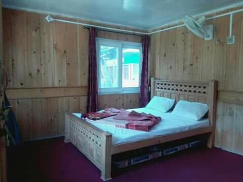a bedroom with a bed with white sheets and a window at Neelum Good View in Shardi