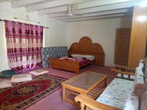 a living room with a bed and a table at Neelum Good View in Shardi