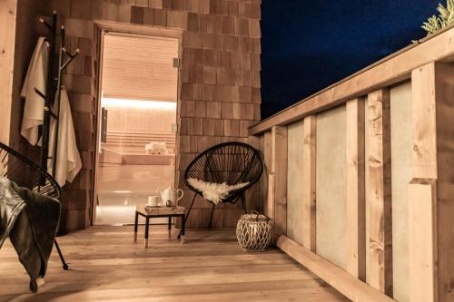 a balcony with a rocking chair and a window at FRAU GANS - pure mountain apartments in Saalbach Hinterglemm