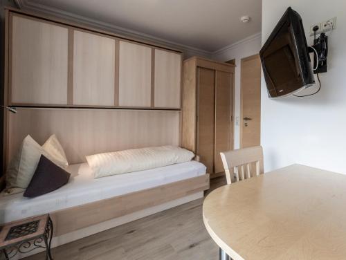 a small room with a bed and a table at FRAU GANS - pure mountain apartments in Saalbach Hinterglemm