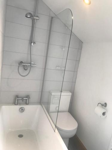 a bathroom with a tub and a toilet and a mirror at No 6 Elizabeth Street in Congleton