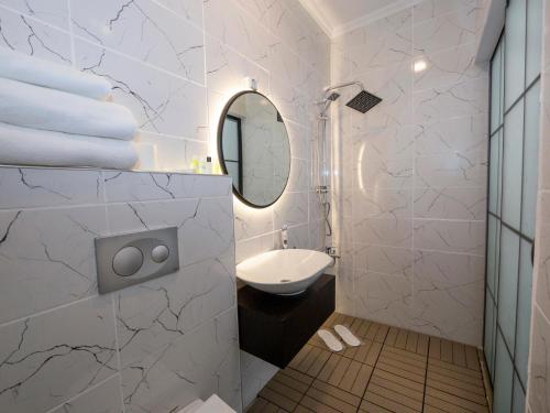 bagno bianco con lavandino e specchio di Miss Suite a Istanbul