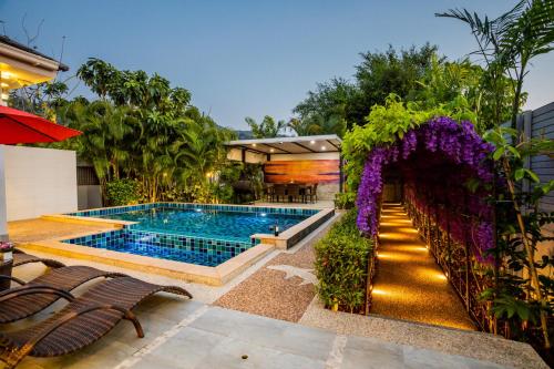 a backyard with a swimming pool and purple flowers at 3 Bedroom Exclusive Private Pool Villa Smooth as Silk in Ao Nang Beach