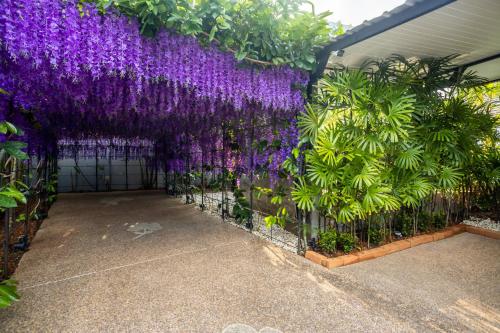 a garden with purple flowers on a fence at 3 Bedroom Exclusive Private Pool Villa Smooth as Silk in Ao Nang Beach