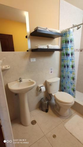 y baño con aseo y lavamanos. en Hotel Caxa Wasi, en Cajamarca