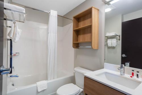 a bathroom with a sink and a toilet and a tub at Microtel Inn Suites by Wyndham South Hill in South Hill