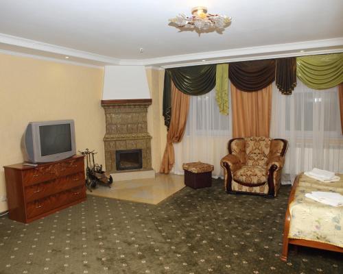 a living room with a tv and a fireplace at ВІКОНТ in Chyshky